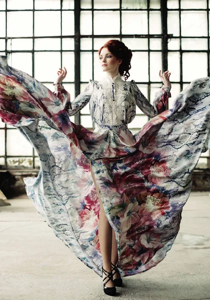 Элегантная женщина с летающим платьем в комнате дворца — стоковое фото