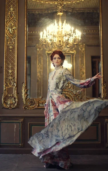 Κομψότητα γυναίκα με ιπτάμενο φόρεμα στην αίθουσα του παλατιού — Φωτογραφία Αρχείου