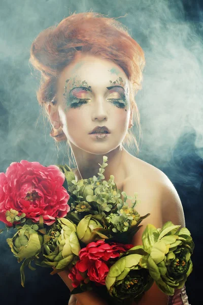 Mooie redhair vrouw bedrijf bloemen — Stockfoto