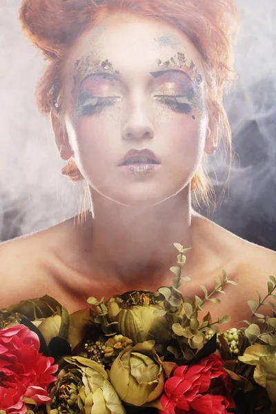 Mooie redhair vrouw bedrijf bloemen — Stockfoto