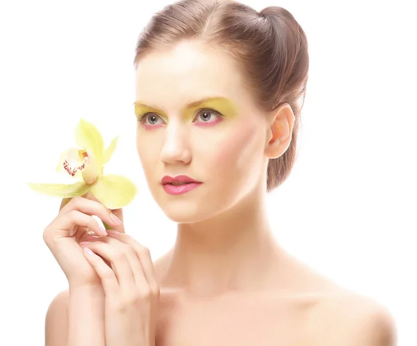 Jeune femme avec maquillage lumineux tenant orchidée — Photo