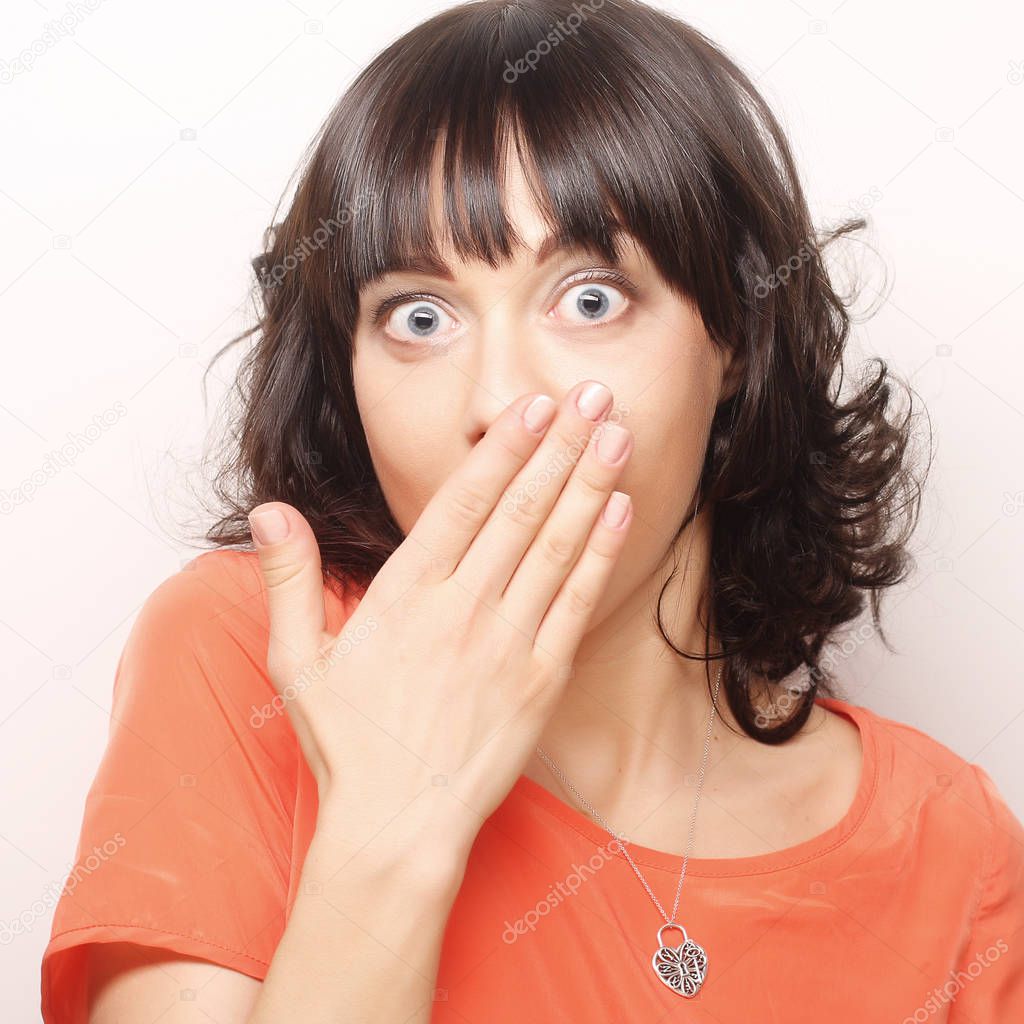 Young woman with hands over mouth.
