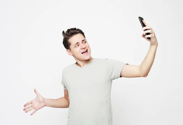 Foto de un hombre guapo sonriendo en la cámara tomando selfie — Foto de Stock