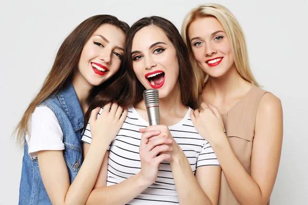 Meninas de beleza com um microfone cantando e se divertindo juntos — Fotografia de Stock