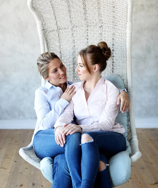 Mature motherand daughter hugging each other in  armchair. — Stock Photo, Image