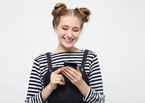 Спосіб життя і концепція людей: портрет щасливої молодої дівчини-підлітка, що використовує мобільний телефон — стокове фото