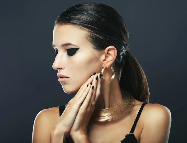 Mooie vrouw met avond make-up en gouden sieraden. — Stockfoto