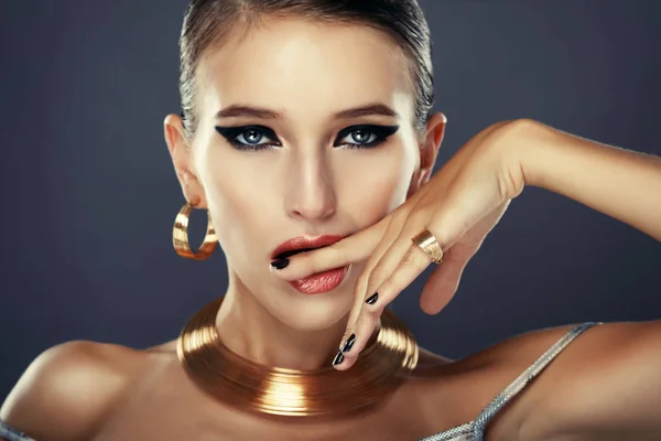 Mooie vrouw met avond make-up en gouden sieraden. — Stockfoto