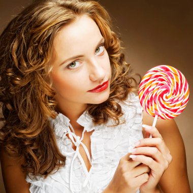 bir lolipop onun elinde olan kıvırcık kız 