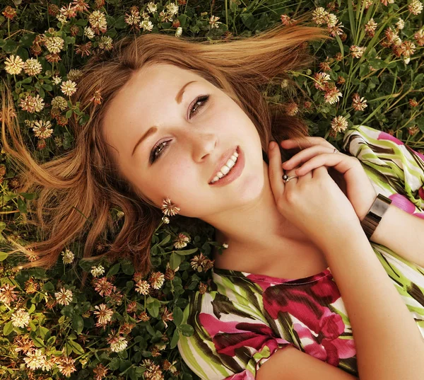 Jeune belle fille pose sur une herbe — Photo