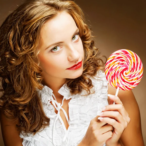 Curly  girl with a lollipop in her hand — Stock Photo, Image