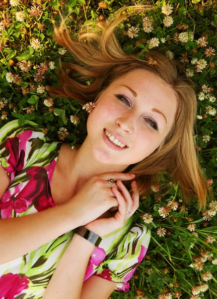 Young beautiful girl lays on a grass — Stock Photo, Image