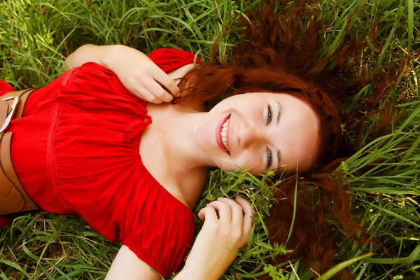 Joven hermosa chica se acuesta en una hierba — Foto de Stock