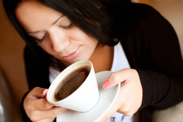 Jovem mulher sentada em um café bebendo café — Fotografia de Stock