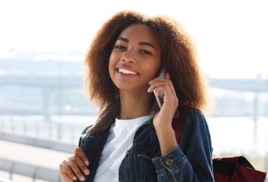 Sokağın ortasında telefon kullanan güzel afro Amerikalı kadın. İletişim ve yaşam tarzı kavramı.