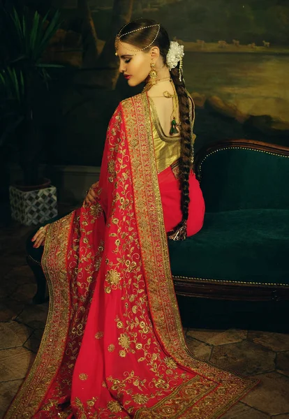 美丽的印度女孩在家里的肖像微笑。带着黄金珠宝套装的年轻女模特 . — 图库照片