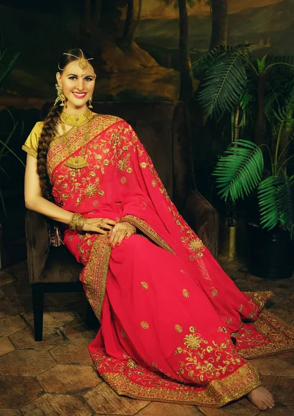 Portré mosolyog gyönyörű indiai lány otthon. Fiatal nő modell arany ékszer készlet . — Stock Fotó