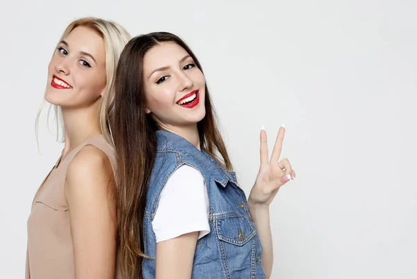 Estilo de vida y concepto de la gente: Dos amigas jóvenes de pie juntas y divirtiéndose. —  Fotos de Stock