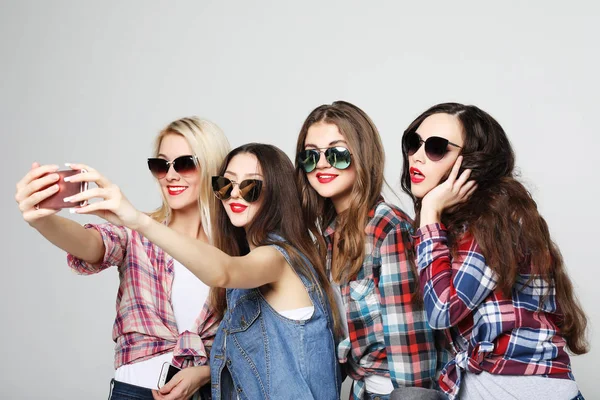 Fyra glada tonårstjejer med smartphone tar selfie — Stockfoto