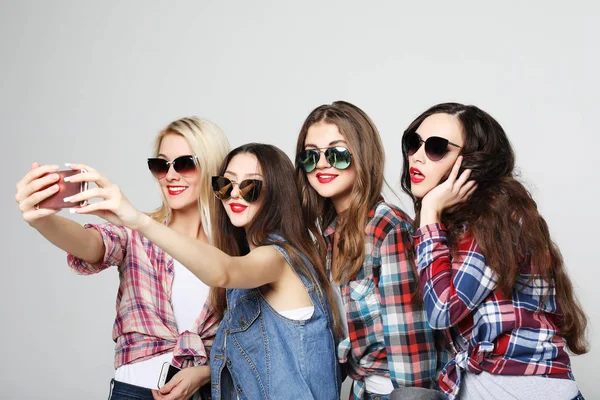 Cuatro chicas adolescentes felices con teléfono inteligente tomando selfie — Foto de Stock