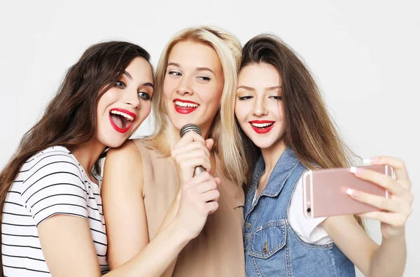 Beauty girls with a microphone singing and having fun together — Stock Photo, Image