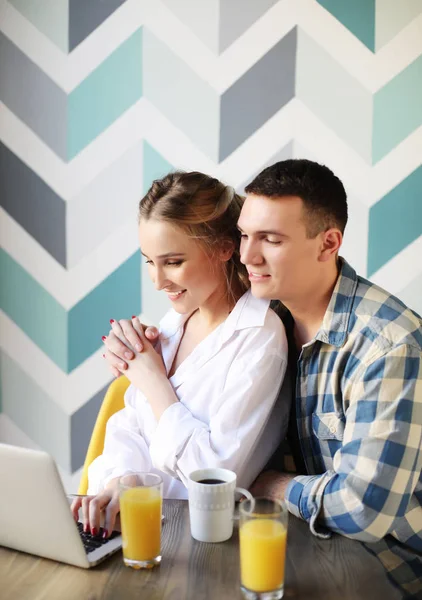 Loving couple having breakfast   and looking at laptop computer — Stock Photo, Image