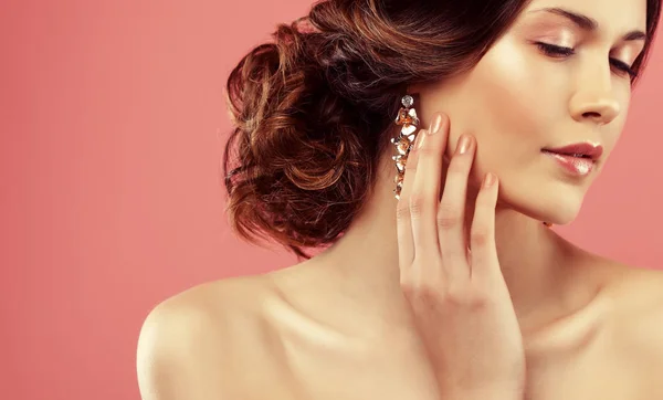 Pendientes de boda en una mano femenina, ella toma los pendientes, llevar pendientes . — Foto de Stock