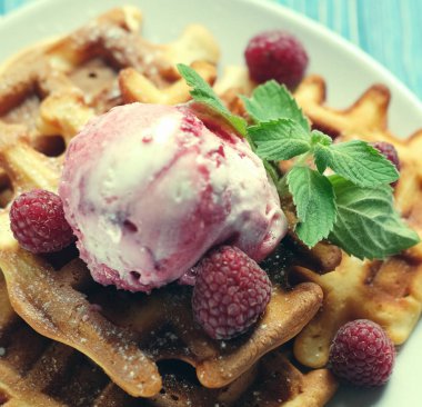 Waffle ahududu Ice cream ve nane ile dekore edilmiş mavi ahşap arka plan üzerinde taze frambuaz