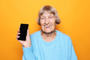 Yeni akıllı telefonlu olgun bir kadının resmi..