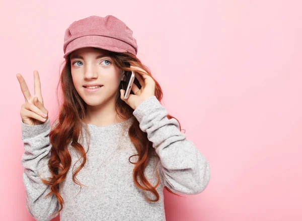 Люди, технологии и концепция Интернета - маленькая девочка со смартфоном на розовом фоне — стоковое фото