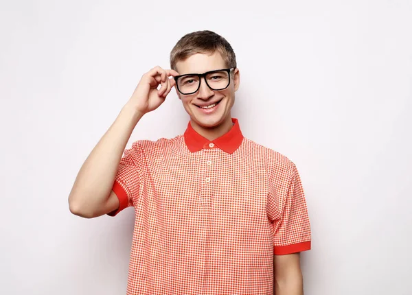 Retrato de un joven inteligente con anteojos parados sobre fondo blanco — Foto de Stock