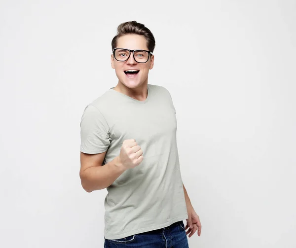 Feliz joven guapo hombre haciendo gestos y manteniendo la boca — Foto de Stock