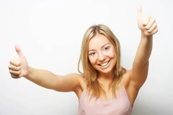 Usmíval se krásná mladá žena ukazuje palec nahoru gesto — Stock fotografie