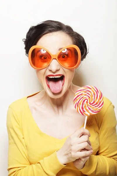 Mujer usando gafas de sol grandes sosteniendo piruleta — Foto de Stock