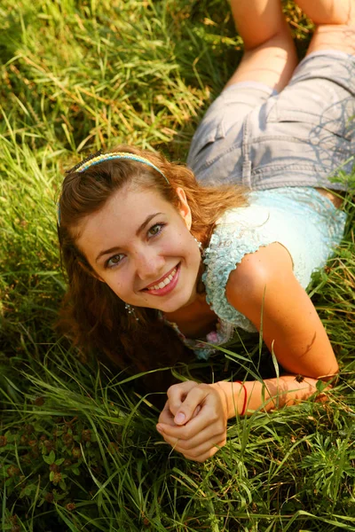 Молодая женщина на открытом воздухе в траве в летнее время — стоковое фото