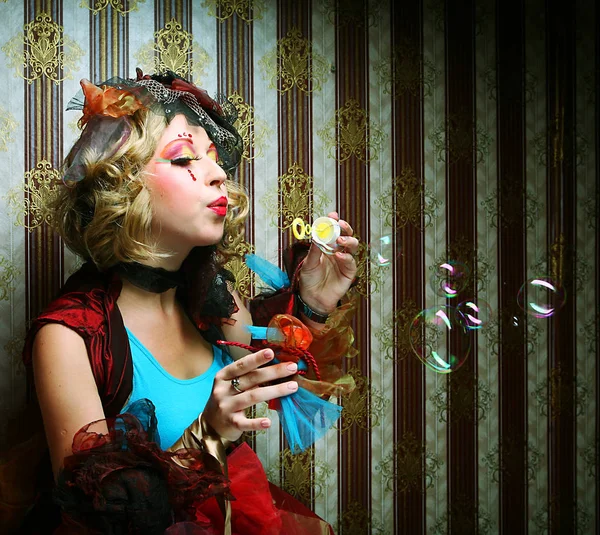 Fashion model with creative make-up blowing soap bubbles. Royalty Free Stock Images