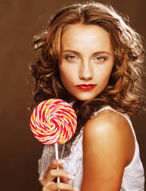 bir lolipop onun elinde olan kıvırcık kız 