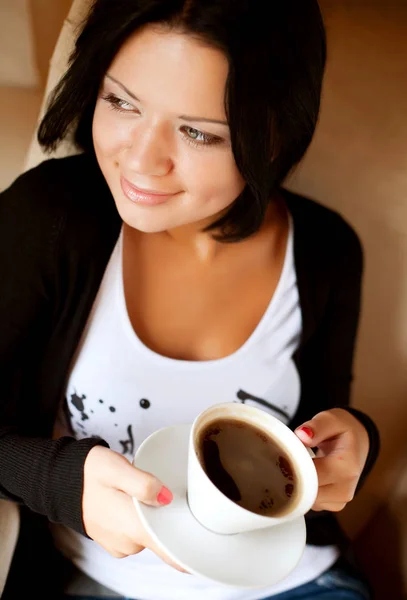 Młoda kobieta siedzi w kawiarni i pije kawę — Zdjęcie stockowe