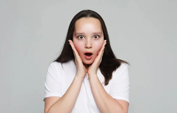 Beautiful girl surprised and shocked looks on you. — Stock Photo, Image