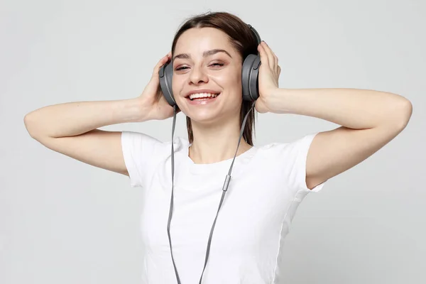 Hermosa mujer joven escuchando música en los auriculares —  Fotos de Stock