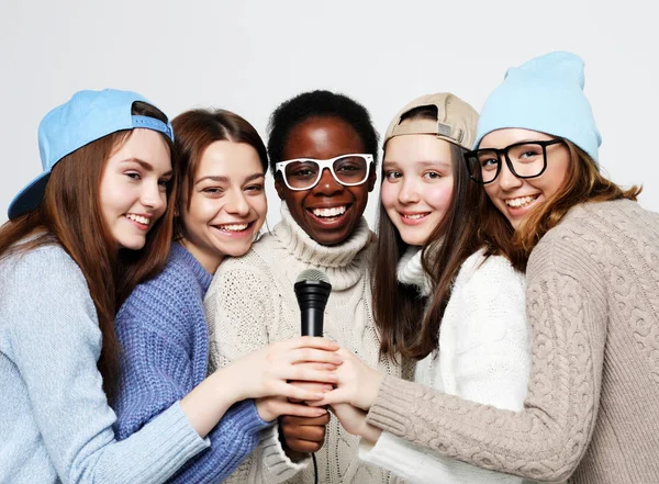 diverse multi nation girls group, teenage friends company cheerful having fun with microphone