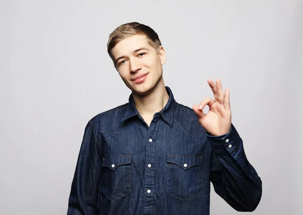 Cheerful young man showing okay gesture — Stock Photo, Image