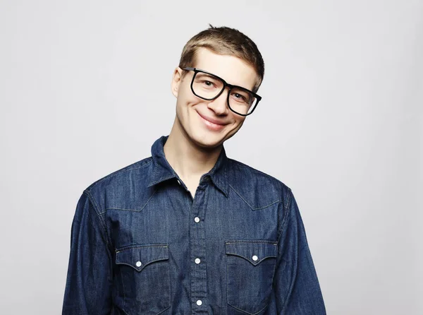 Portrait of a smart young man wearing eyeglasses standing against white background — Stock Photo, Image