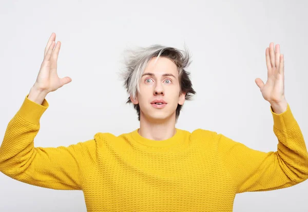 Aantrekkelijke man dragen gele trui verbaasd en verbaasd in shock en verrassing gezicht uitdrukking — Stockfoto