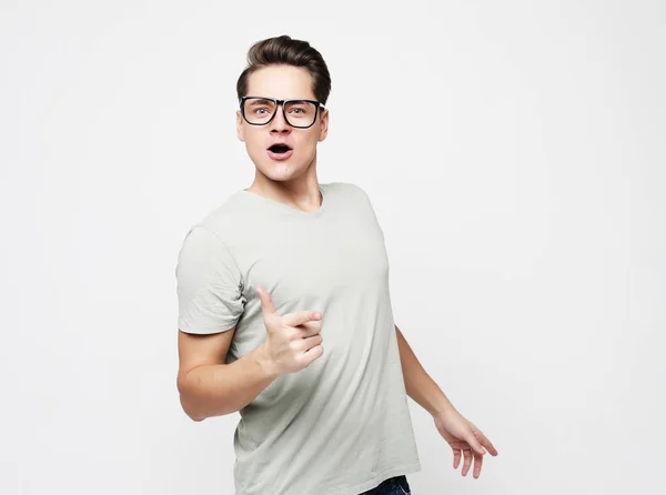 Happy young handsome man gesturing and keeping mouth — Stock Photo, Image