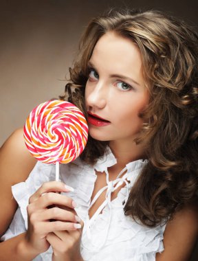  Güzellik kıvırcık kız portre renkli lolipop tutan.