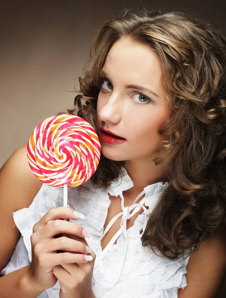 Beauty curly girl portrait holding colorful lollipop. — Stock Photo, Image