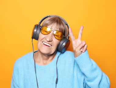 Müzik dinleyen ve baş parmağını kaldıran komik yaşlı kadın.. 