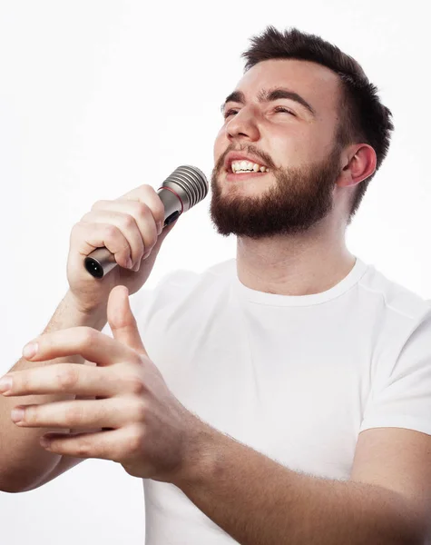 सफेद शर्ट में युवा दाढ़ी वाला आदमी माइक्रोफोन में गा रहा है — स्टॉक फ़ोटो, इमेज