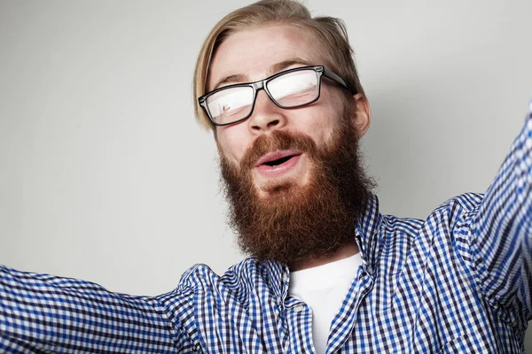 Portrét mladého vousatý muž selfie a držení fotoaparátu — Stock fotografie